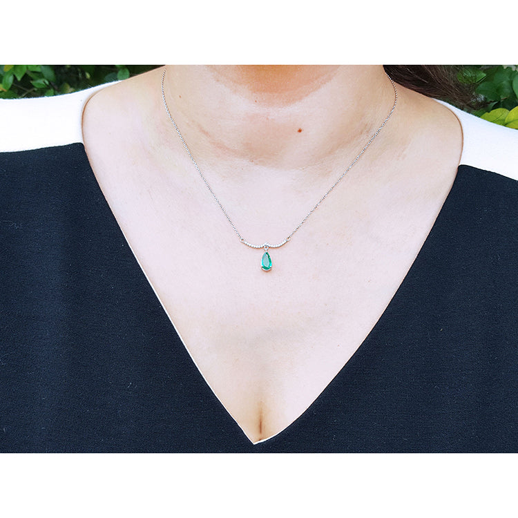 Mother&#39;s Day gift necklace natural Colombian emerald dangling from a wavy central bar with diamonds pave set in 14k white gold