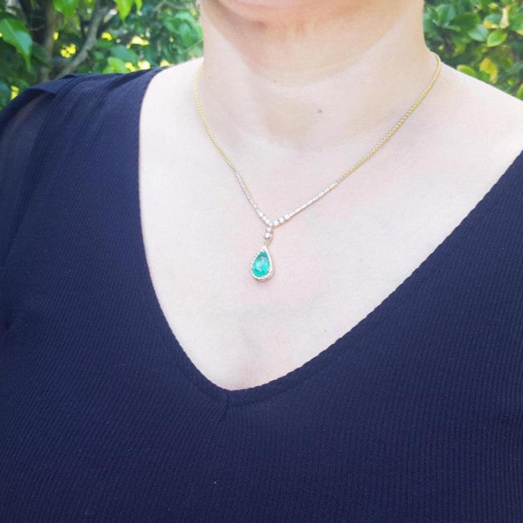 woman wearing a Colombian emerald necklace pear cut natural 3.30 carats crafted in 18k yellow gold