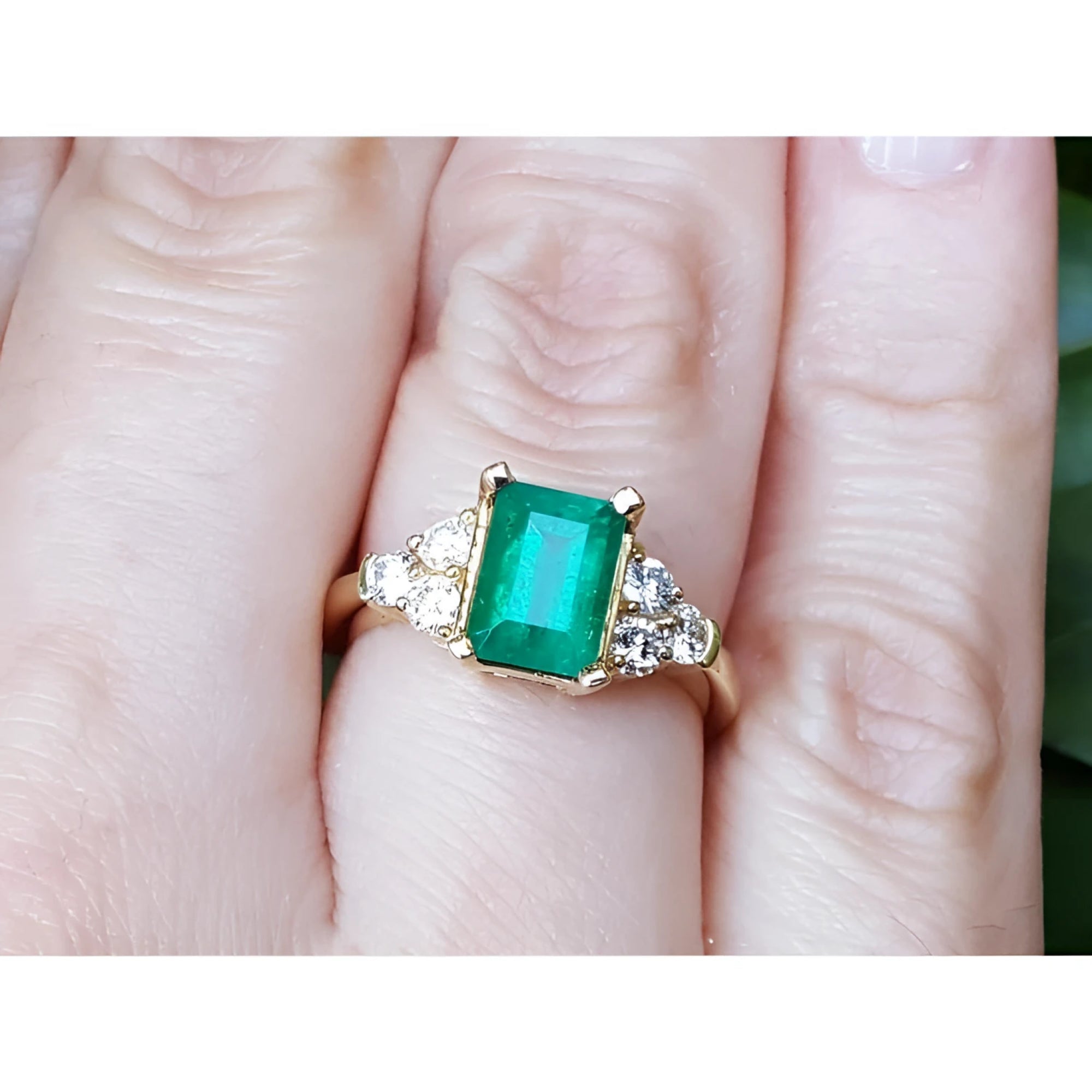 A colombian emerald-cut emerald ring for ladies on a finger.