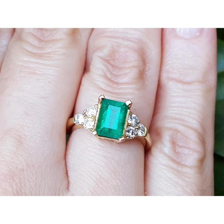 A colombian emerald-cut emerald ring for ladies on a finger.