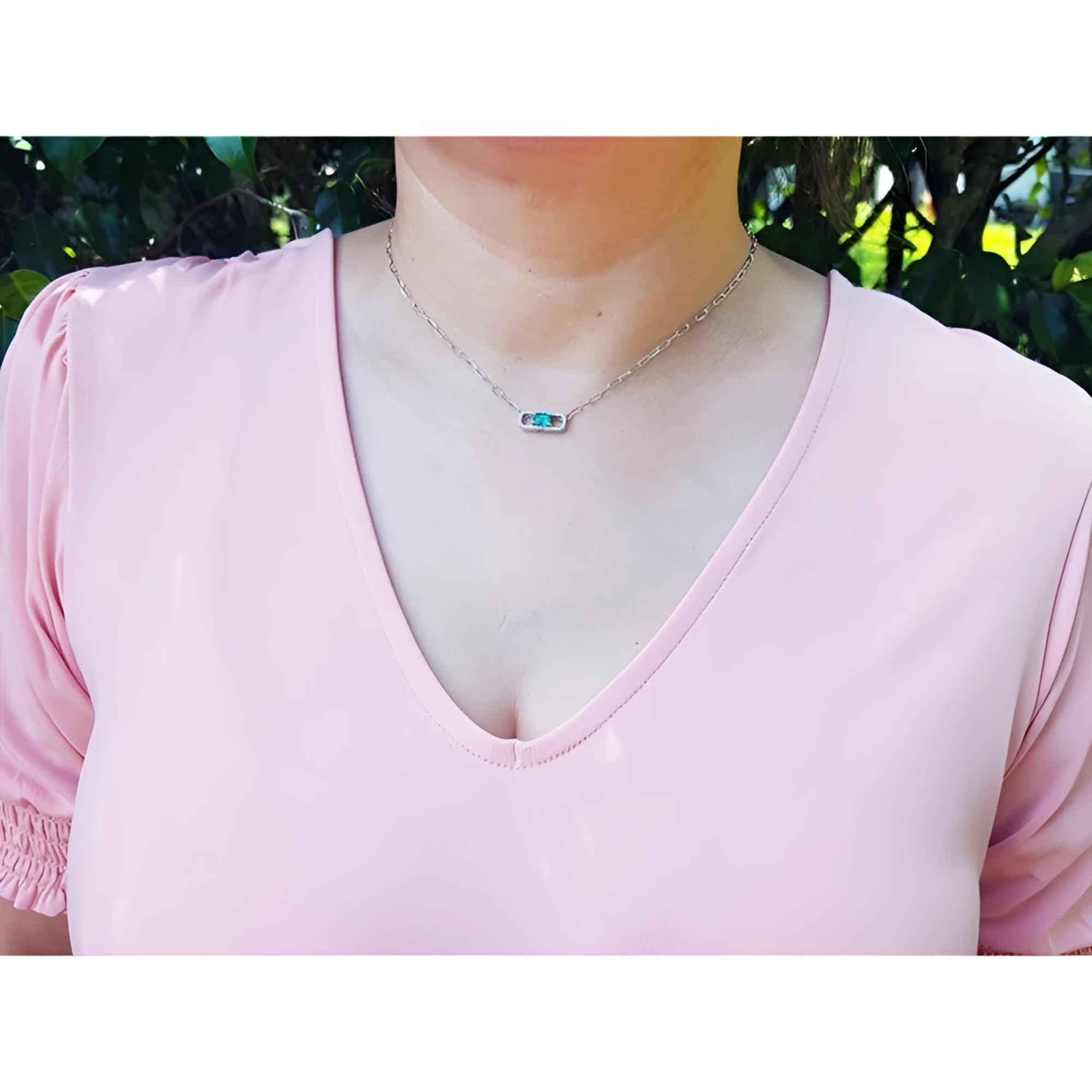 0.68 ct Colombian emerald and diamond paper clip necklace in 18K white gold on a model.