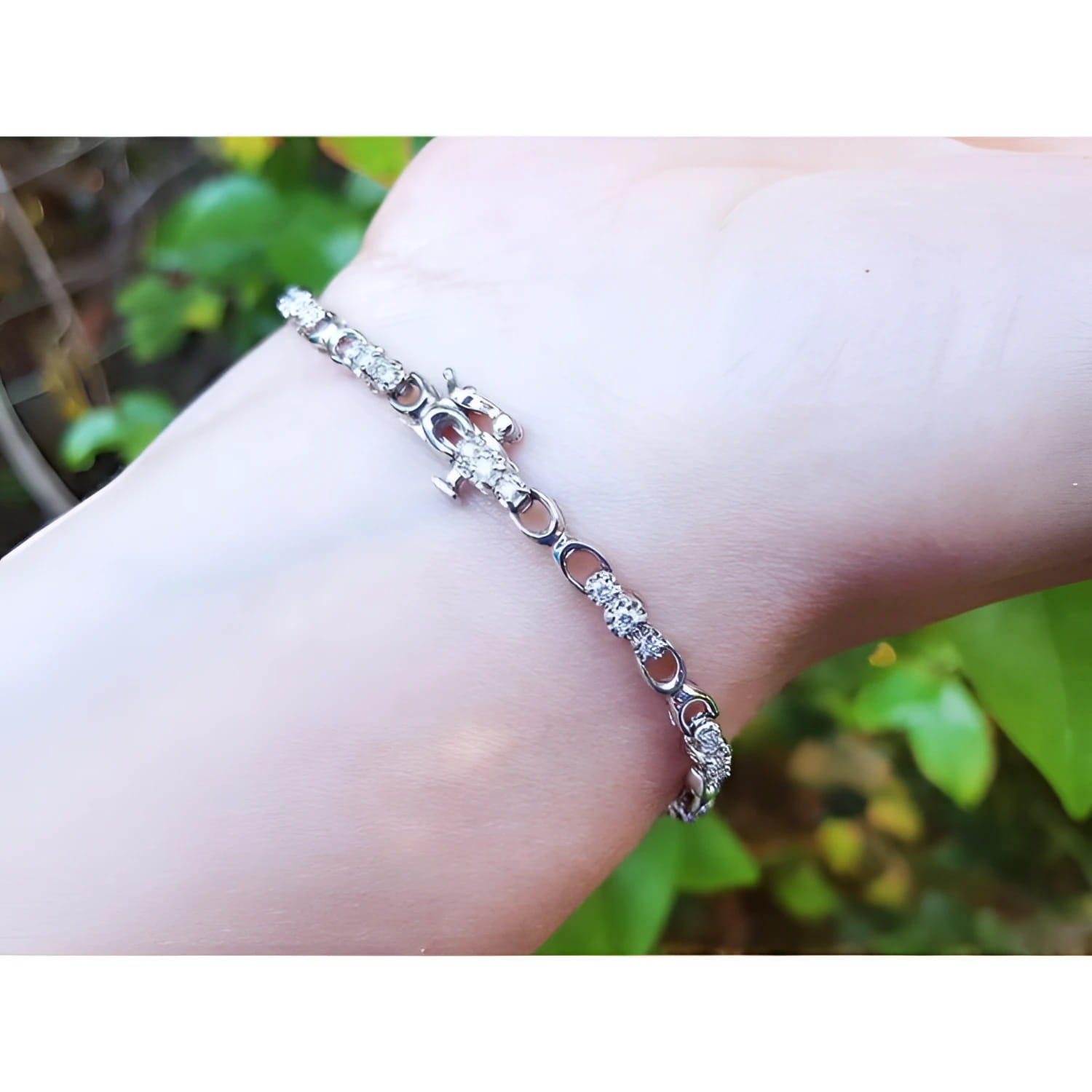 14K white gold bracelet with round diamonds on a wrist, featuring a delicate chain design.