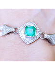 Emerald-cut Colombian emerald and pearls bracelet crafted in 18k white gold on a wrist.