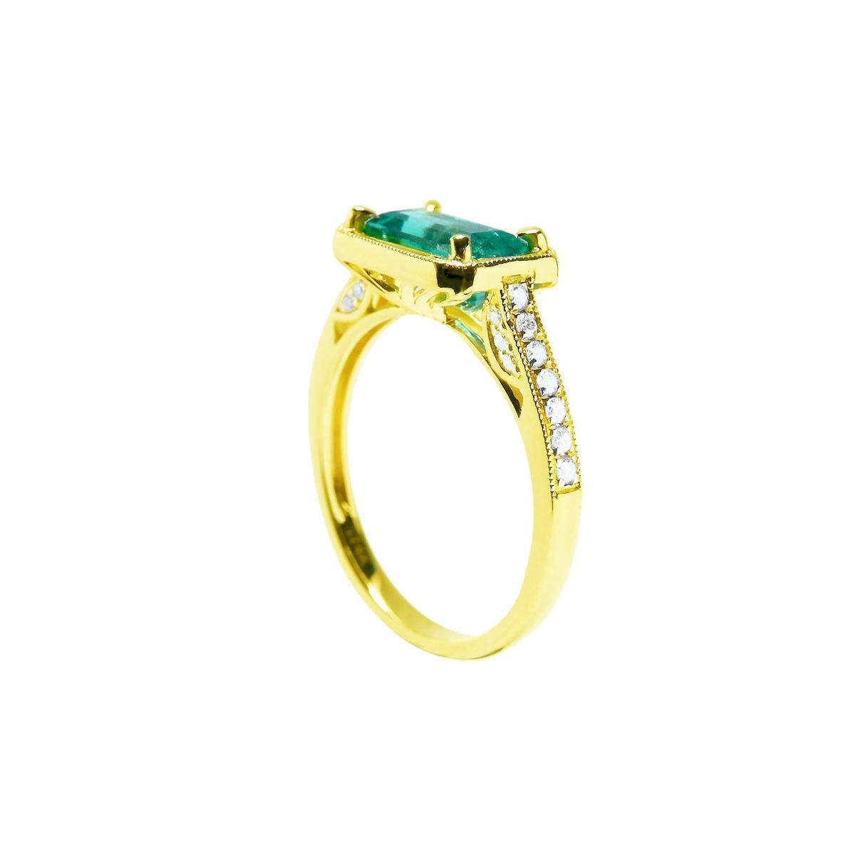 From a partial side angle, this emerald ring reveals the top setting, a portion of the gallery, and the band design.