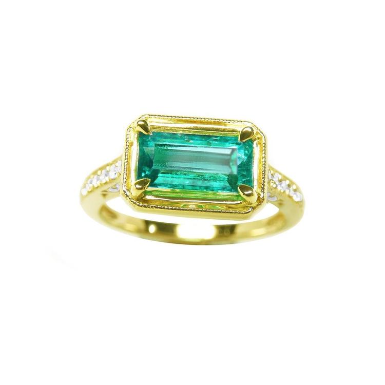 This 14k gold genuine colombian emerald ring displays the centered gemstone in prong set and accent diamonds.