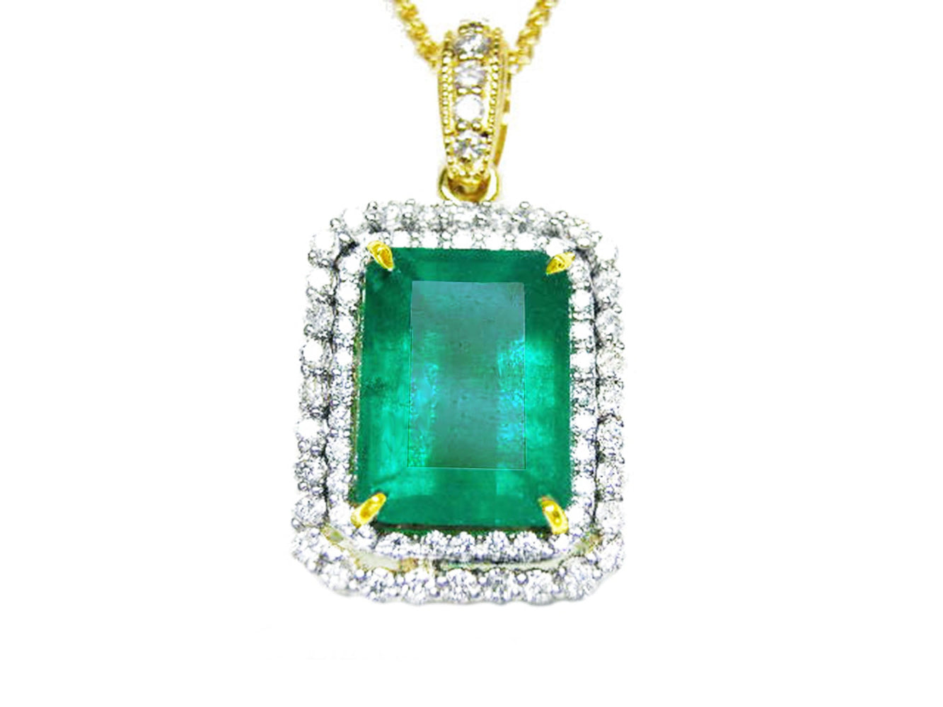 The topside of a pendant with a rectangular emerald encircled by a double halo diamond in yellow gold.