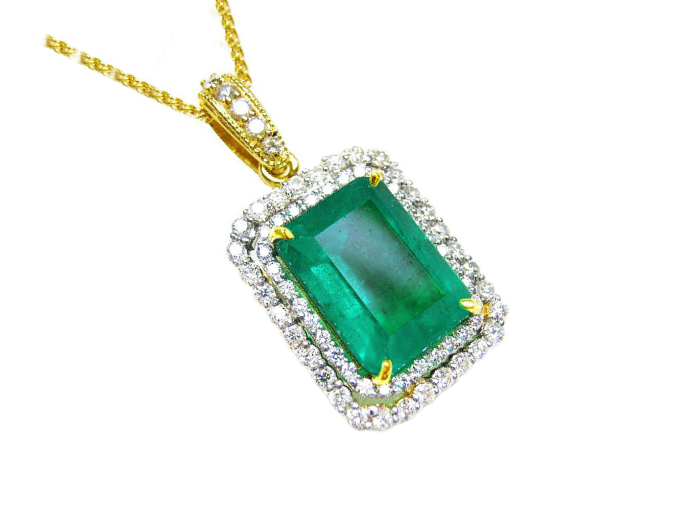 A yellow gold emerald pendant displaying the topside rectangular emerald surrounded by a double halo diamond.