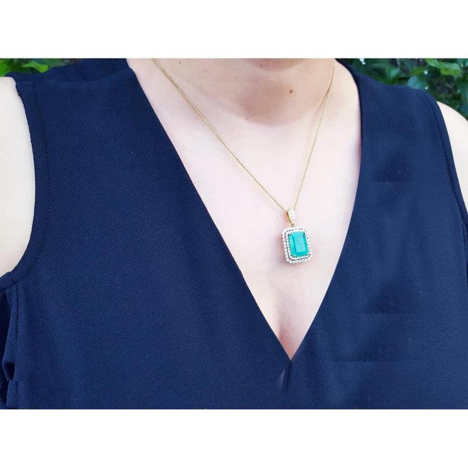 18K yellow gold emerald pendant with a rectangular emerald-cut stone and double halo natural diamonds.