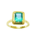 Solitaire natural emerald ring rectangular emerald-cut emerald and prong set in 14k yellow gold.