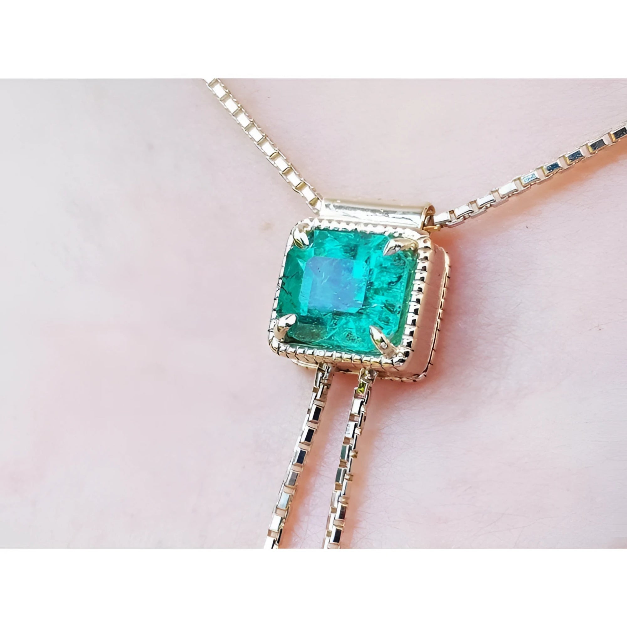 Emerald-cut natural Muzo Colombia emerald lariat necklace in 14K gold with milgrain detail on a box chain.