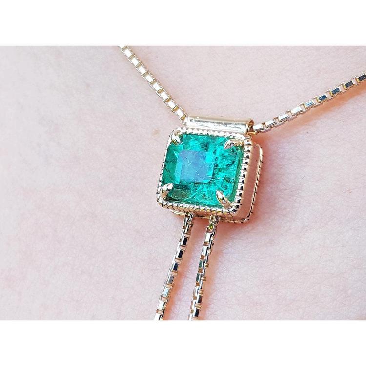 Emerald-cut natural Muzo Colombia emerald lariat necklace in 14K gold with milgrain detail on a box chain.