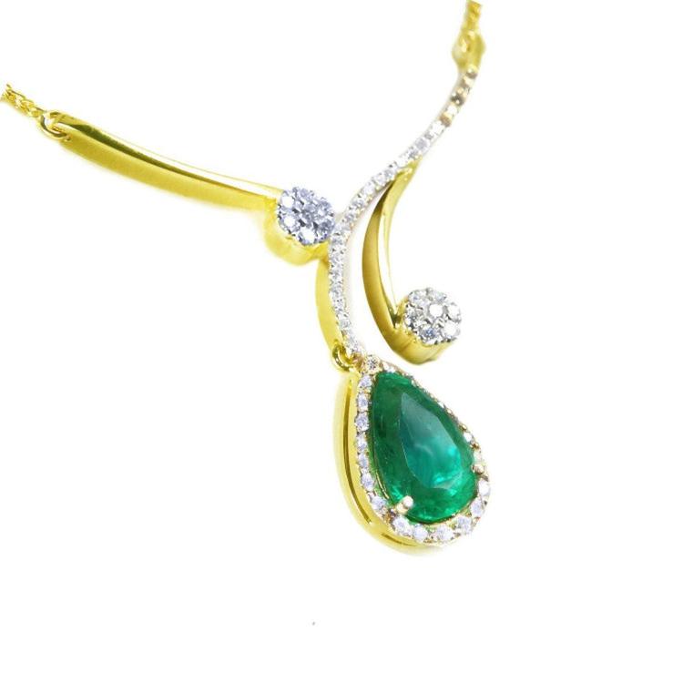 A 18k yellow gold necklace with a natural teardrop emerald pendant halo diamond.